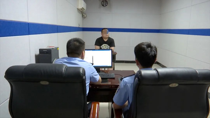 ▲涉诈逃犯李某在仙桃市沙湖派出所接受讯问