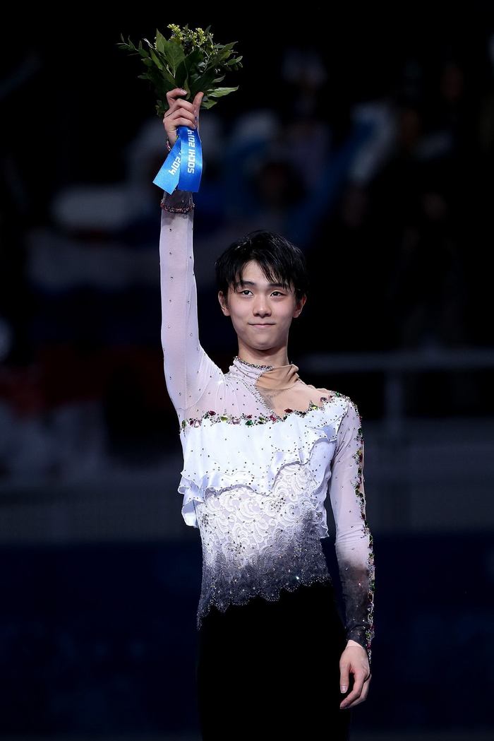 　2014年2月14日，索契冬奥会花滑男单自由滑比赛中，羽生结弦夺冠后单手高举鲜花。