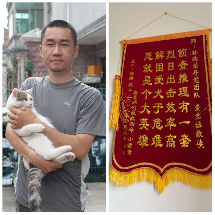 抱着自己猫的孙锦荣，和墙上的一面锦旗。
