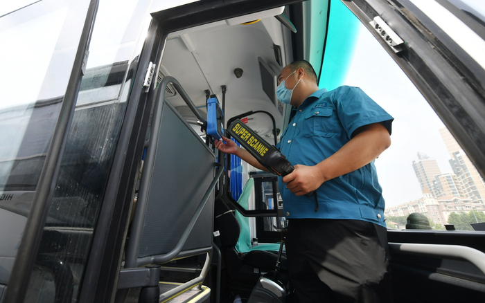 乘客登车时，驾驶员也会拿着手持安检仪和测温仪，对乘客进行快速检测。新京报记者 王贵彬 摄