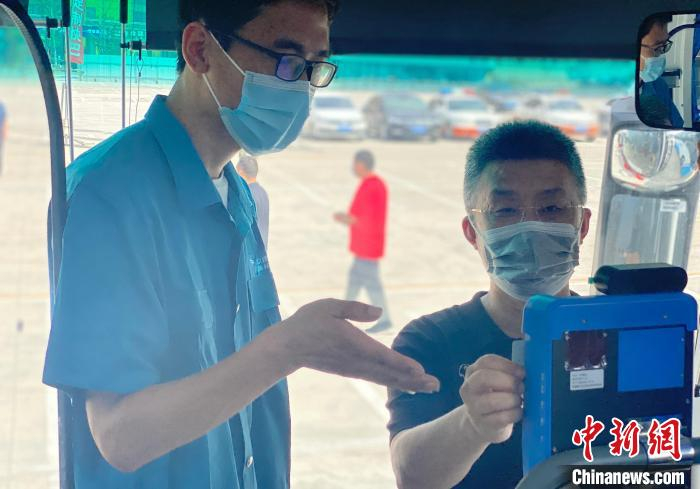 图为通勤定制快巴驾驶员指引乘客扫描身份证试乘。　高澍 摄