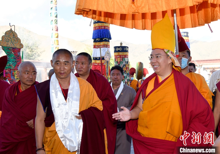 7月19日上午，贡嘎曲德寺僧人们组成仪仗队、高举宝伞，用藏传佛教最高礼仪迎接班禅。   中新社记者 李林 摄