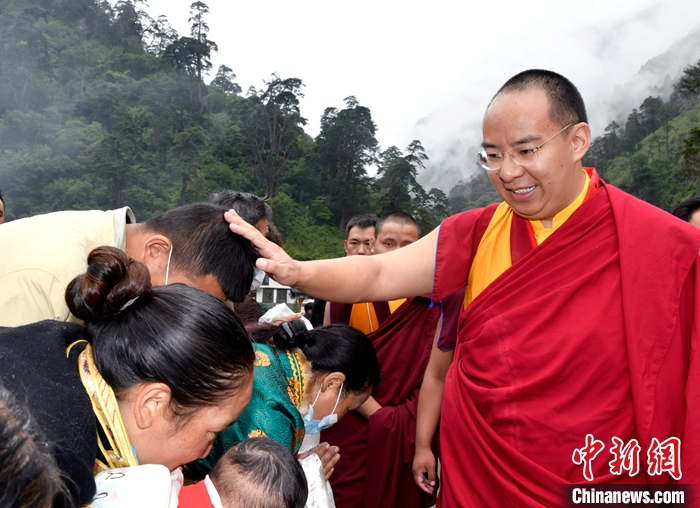 7月21日，班禅在隆子县扎日乡珞瓦新村为信众摸顶赐福。中新社发 李林 摄