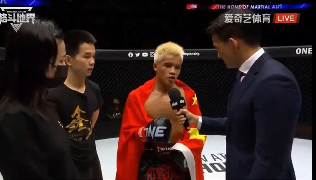 张沛勉披上国旗，接受采访。视频截图 