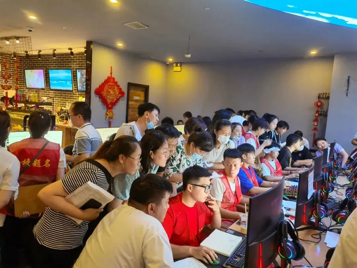 ▲7月15日下午，呼和浩特一家网吧内，考生和家长正在围观操盘手填报志愿。新京报记者 李照 摄