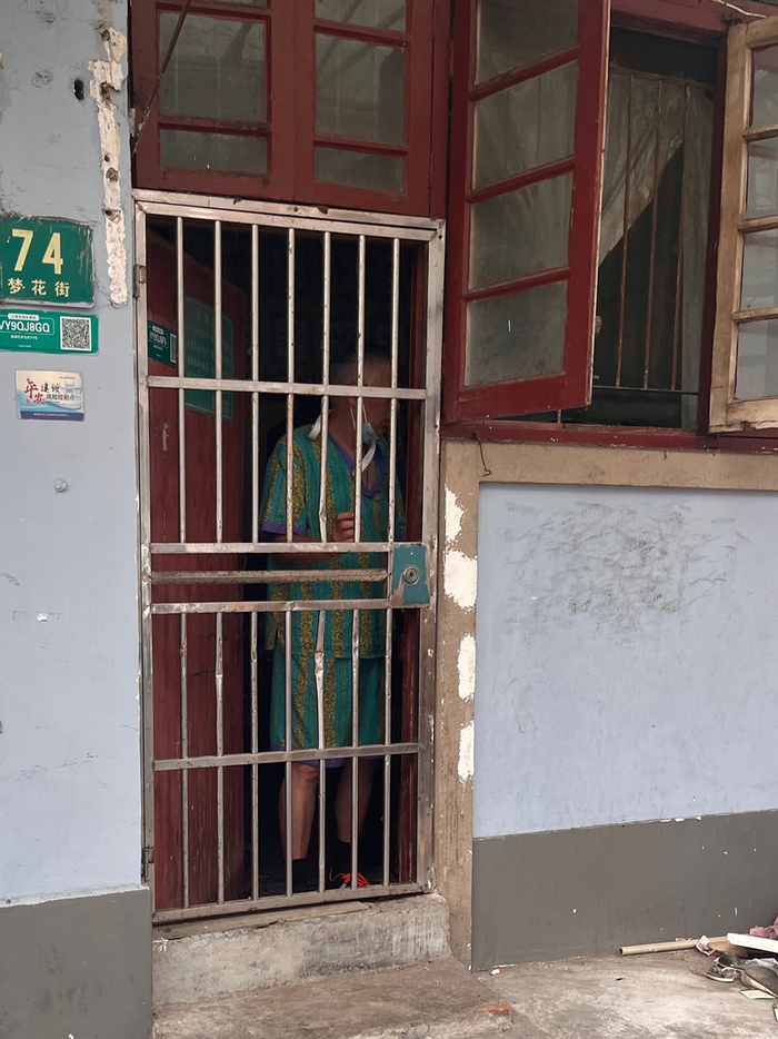 周爷叔正推门而出（该屋门牌号在房子另一边）。澎湃新闻记者 邹佳雯 摄