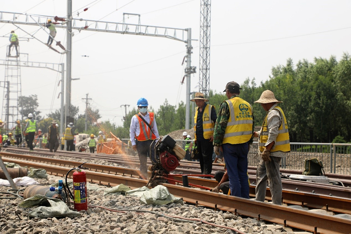 施工作业人员对钢轨进行锯割。 丁玲摄