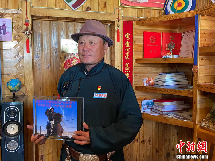 图门向记者展示“十大优秀护边员”奖章。苏亦瑜 摄