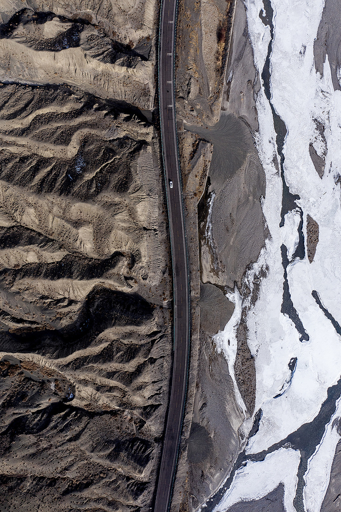 2019年2月8日，独库公路蜿蜒穿行在天山群峰和冰封的库车河之间。资料图
