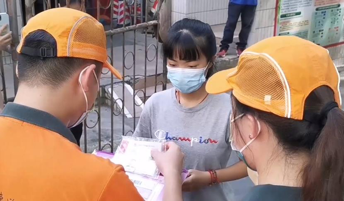 7月18日上午，在南宁市西乡塘区义忠街48号，邮政投递员仔细核对收件人的身份证和准考证。  广西日报视频截图