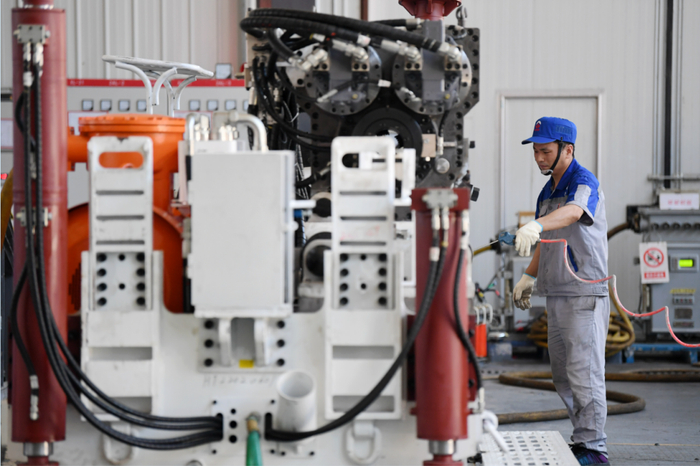 ▲6月17日，陕西省西安市西咸新区的陕西太合智能钻探有限公司，工人准备对智能定向钻机进行性能调试。图/新华社