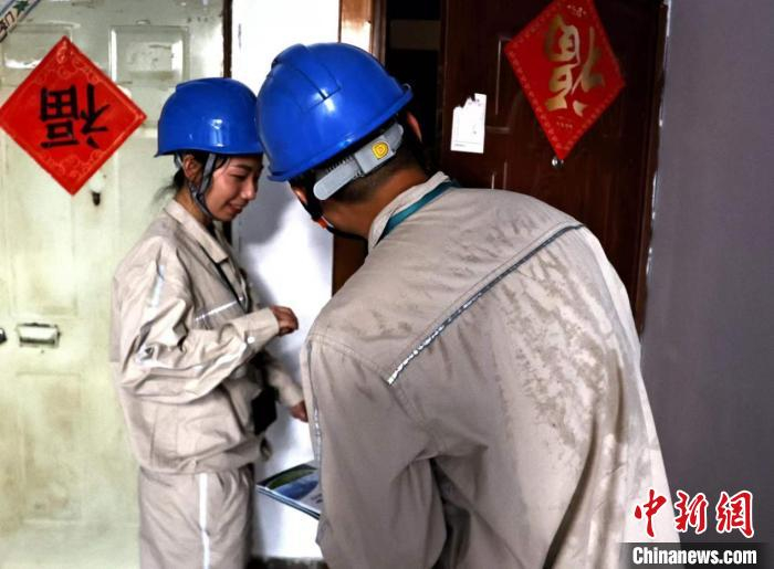 图为国网重庆市南供电公司员工正在巴南区典雅苑小区进行入户高层防火安全宣传。　龚超 摄