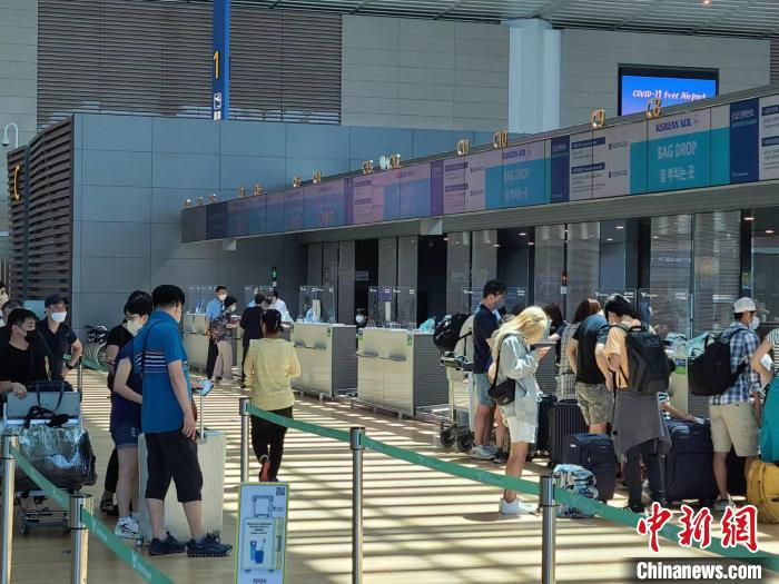 图为7月14日，旅客在韩国仁川机场大韩航空值机柜台办理值机。　刘旭 摄