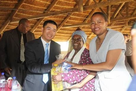 2011年圣诞节前夕，南庚戌与当地官员一起向当地贫困老人捐赠食品。