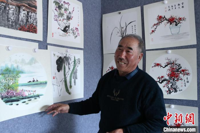 图为刘发介绍自己的画作。　郝建国 摄