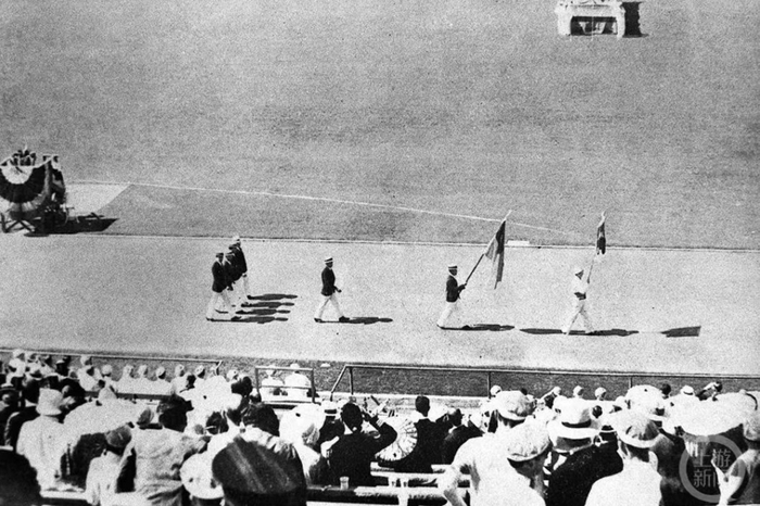 ▲当地时间1932年7月30日下午2点30分，洛杉矶奥运会开幕式，走在第二位举旗者为刘长春，后排左起第二人为刘雪松。