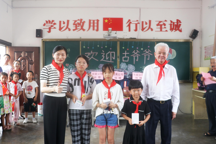 古润金与孩子们合影。企业供图