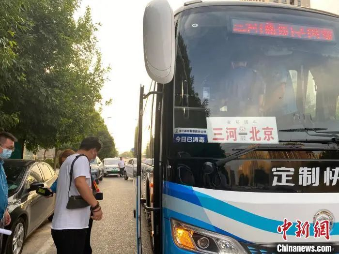 资料图：三河市某小区门口，乘客正在排队等候乘坐通勤定制快巴。高澍 摄