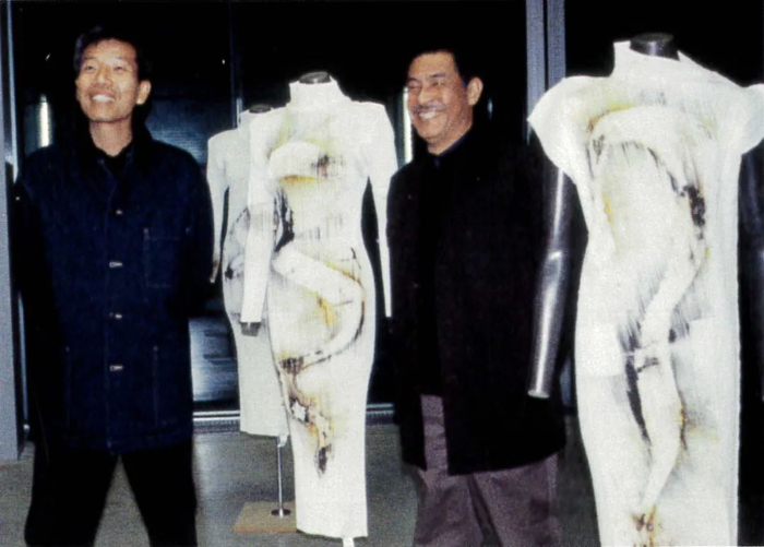 蔡国强与三宅一生于《龙：炸三宅一生服装》爆炸后合影，巴黎。图片来自《Pleats Please》，2012年出版