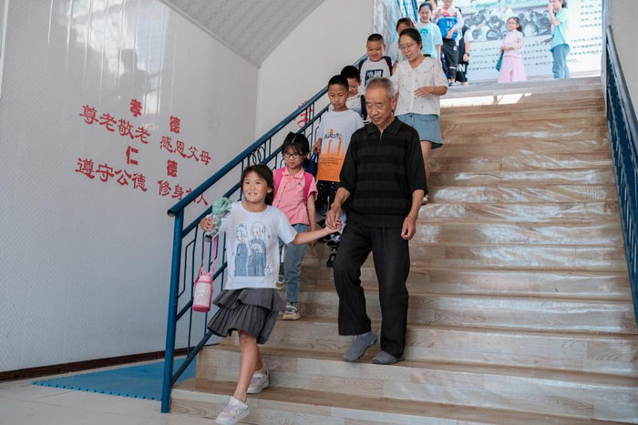 吴富生送孩子们放学。（采访对象供图）