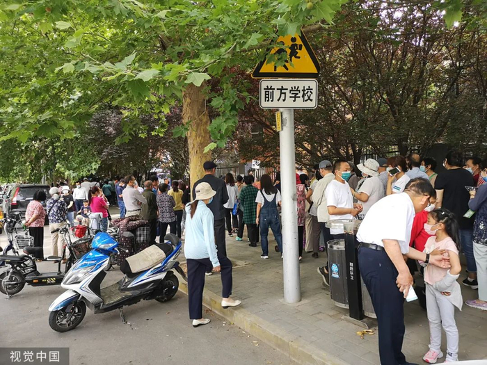 排成长队等待接送孩子的家长。/视觉中国