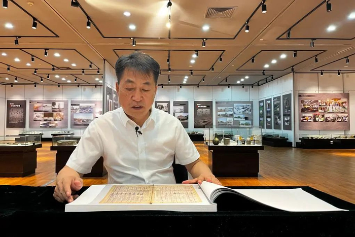 侵华日军第七三一部队罪证陈列馆馆长金成民向记者介绍《关东军化学部留守名簿》（8月13日摄）。新华社记者杨思琪摄