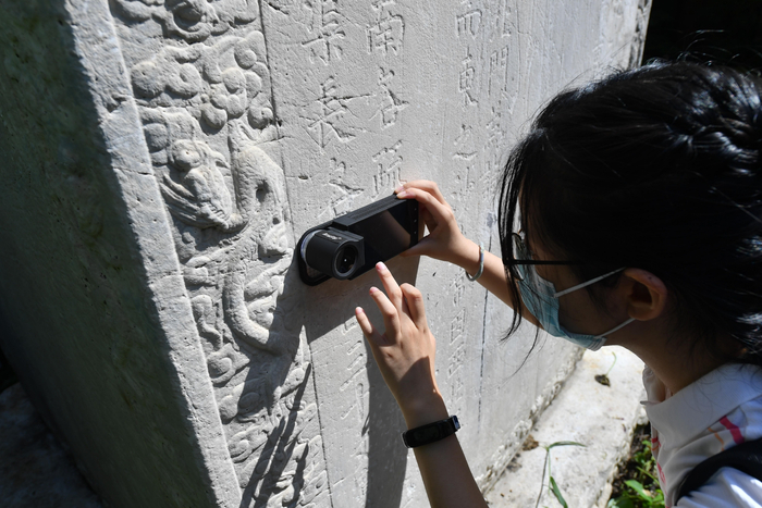 北京建筑大学学生在使用变焦摄像机拍摄石碑表面。新京报记者 李木易 摄