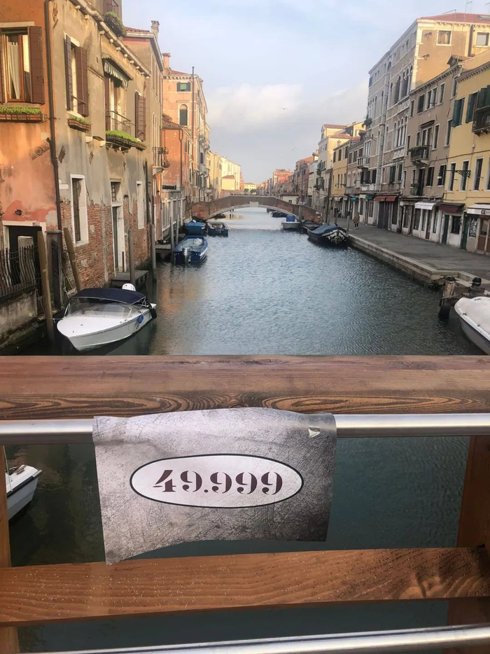 威尼斯古城的建筑物和老桥上出现了“49，999”的贴纸和横幅 