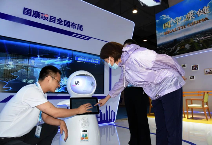 观众在展会上了解一款“24小时老人智能陪护机器人”。新华社记者 李紫恒/摄
