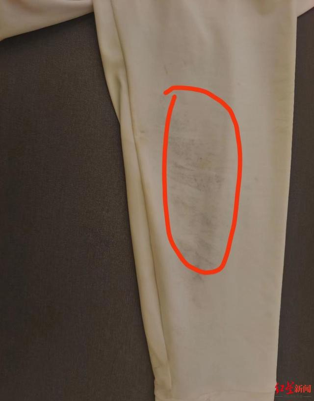 　　↑王女士将防晒衣用水冲了冲，却发现衣服掉胶了