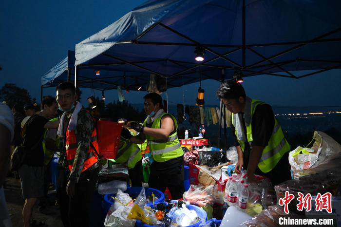 图为志愿者们分发物资。　何蓬磊 摄