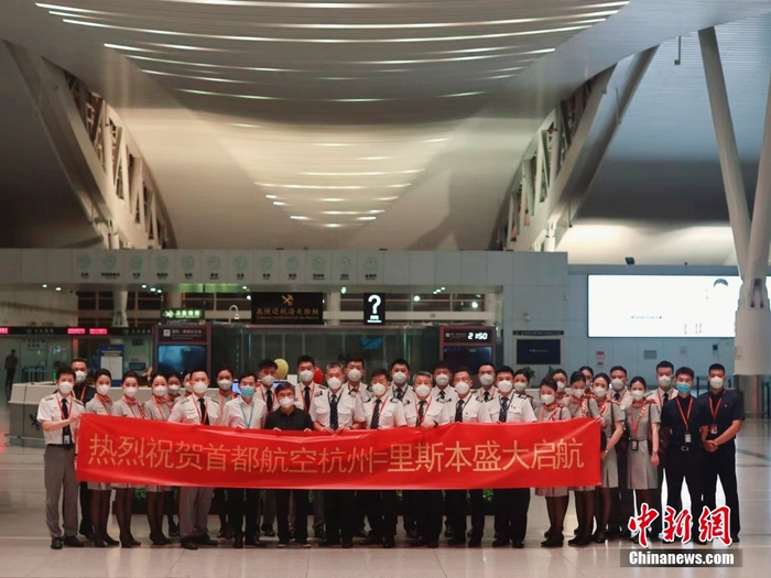 图为航班起飞前，航司的机组人员等在萧山机场合影留念。   中新社发 陈永平 摄
