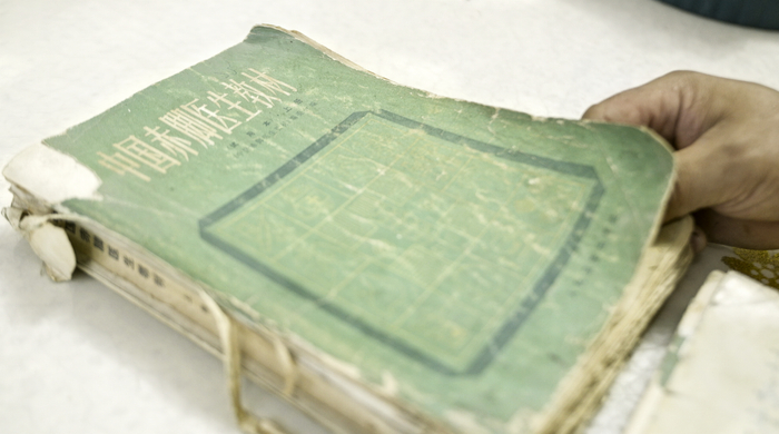 ▲被朱秀林和朱来成翻烂的那本于1982年出版的《中国赤脚医生教材》。&nbsp; 新京报记者 孙霖婧 摄