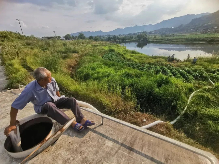 8月26日下午，在开州区正安街道白华水库，辽叶村村民坐在洒水车上协助抽水。李浩 摄