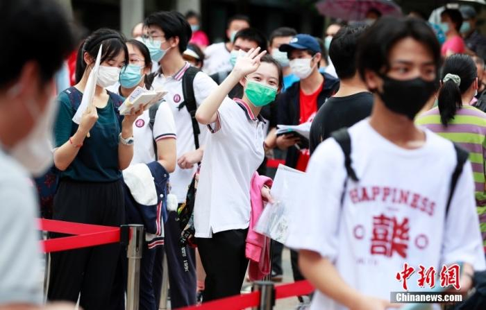 资料图：今年7月上海一名考生在进入考场前向家长挥手致意 中新社记者 汤彦俊摄