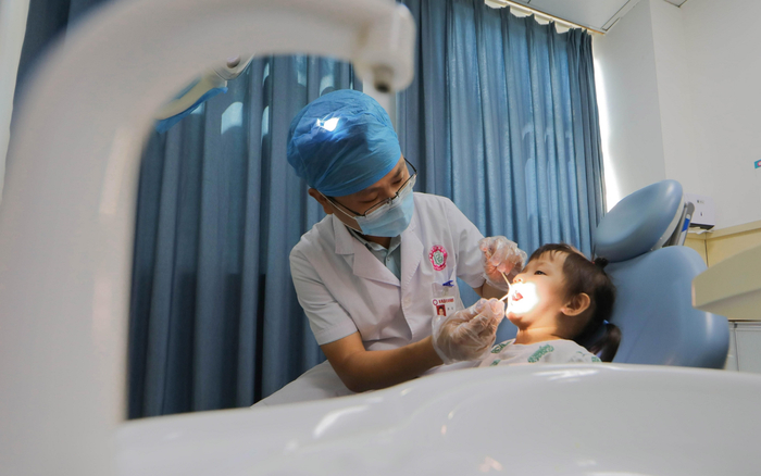 ▲医生正为孩子做口腔检查。图/新华社