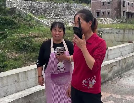 村民使用救援人员提供的卫星电话和亲人联系报平安。