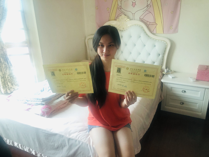 今年8月，杨晓婷收到了本科录取通知书（图左边为盲文版录取通知书）