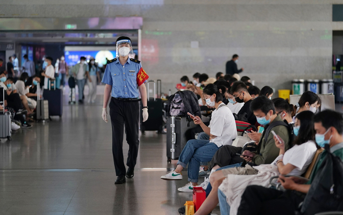 站务员在候车大厅内来回巡视，提醒乘客佩戴好口罩。新京报记者 王贵彬 摄