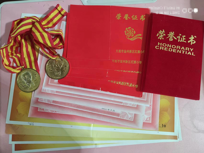 　刘家芃获得的各类奖状、奖牌和证书。