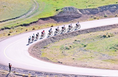 　参赛选手在环赛里木湖公路自行车赛骑行。新华社发