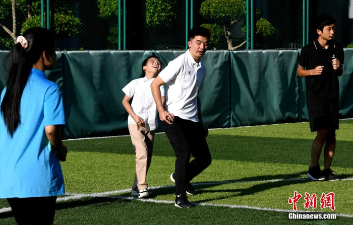 王亚锋牵着队员做示范动作，让他们用肢体去感受。王东明 摄