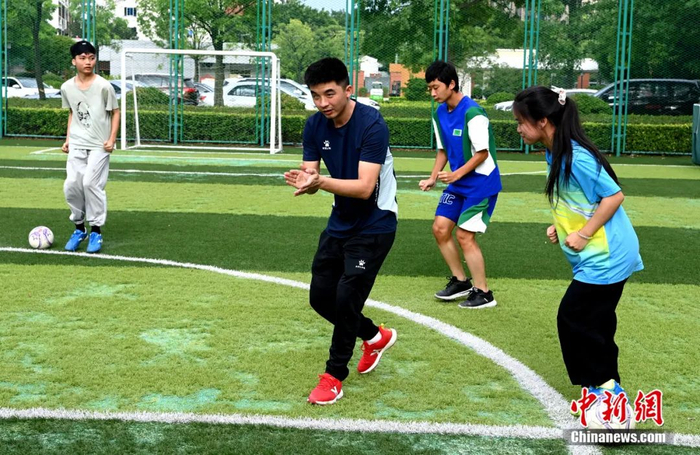 训练时，王亚锋拍掌让队员跟节奏原地跑跳。王东明 摄