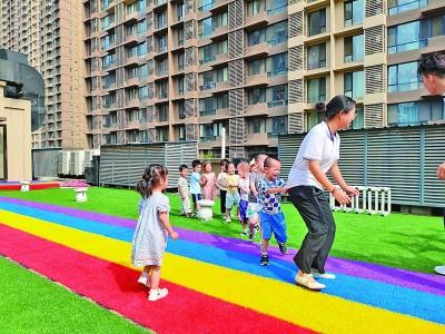 在西安某托育中心，孩子们在玩“老鹰捉小鸡”的游戏。光明图片