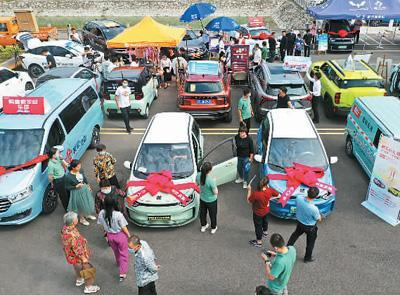 安徽省亳州市蒙城县许疃村文明广场，人们在汽车家电下乡活动现场参观不同款式的汽车。胡卫国摄（人民视觉）