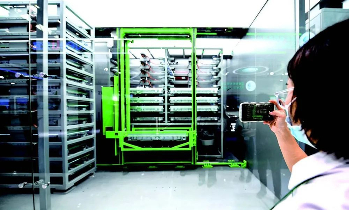 7月21日，在2022世界动力电池大会绿色低碳出行展览会上，参观者用手机录制新能源汽车换电过程