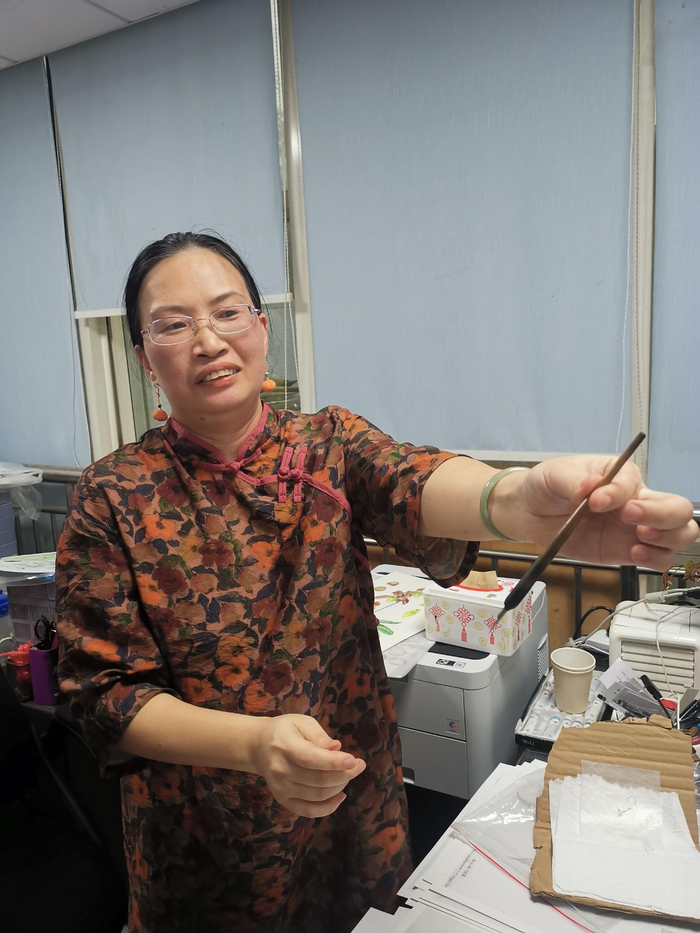 刘运笑介绍她绘制植物科学画使用的钢笔。新京报记者 张璐&nbsp;摄