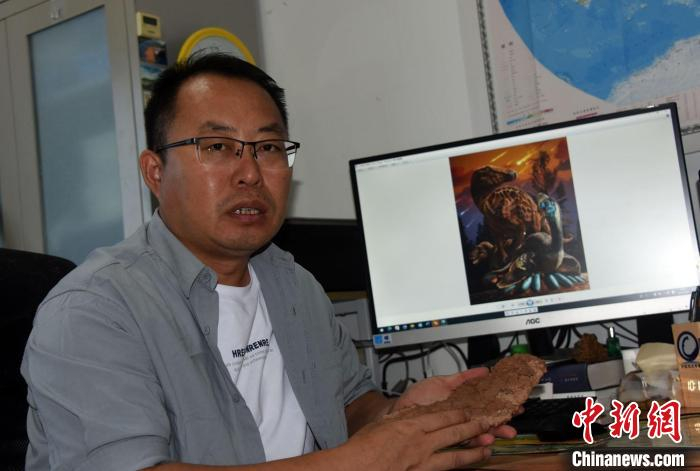 论文通讯作者、中科院古脊椎所副研究员王强介绍本次研究的恐龙蛋化石标本，及山阳盆地三类恐龙复原效果图。　中新社记者  孙自法 摄