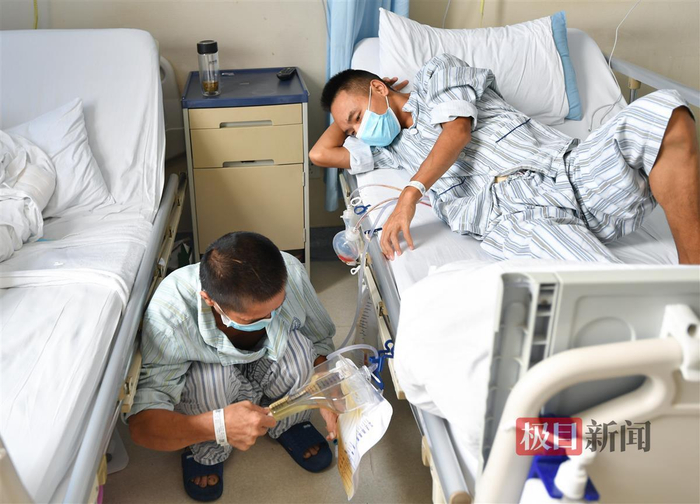 父亲（左）担心儿子情况，术后紧盯各种指标