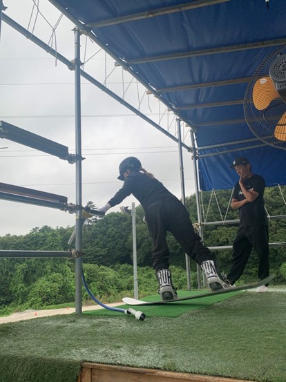 佐藤康弘（右）指导日本单板滑雪选手岩渕丽乐。澎湃新闻 图